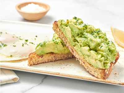 Our thick-cut whole grain artisan toast, fresh smashed avocado, EVOO, lemon and Maldon sea salt with two basted cage-free eggs.