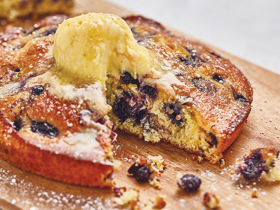 Freshly baked cornbread with sweet and juicy blueberries. Topped with house-whipped lemon butter and lightly dusted with powdered cinnamon sugar.