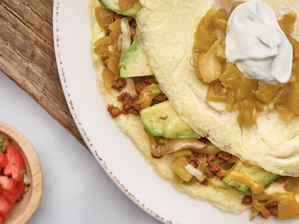 Chorizo, avocado, green chiles, house-roasted onions, Cheddar and Monterey Jack. Topped with all-natural sour cream and served with a side of housemade pico de gallo.