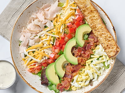 Organic mixed greens, romaine, bacon, turkey breast, a hard-boiled cage-free egg, tomatoes, avocado and Bleu cheese crumbles with buttermilk ranch dressing.