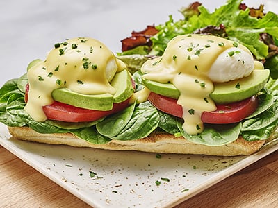 Two poached cage-free eggs atop toasted ciabatta with fresh baby spinach, avocado and vine-ripened tomato and covered with hollandaise. Served with lemon-dressed organic mixed greens.