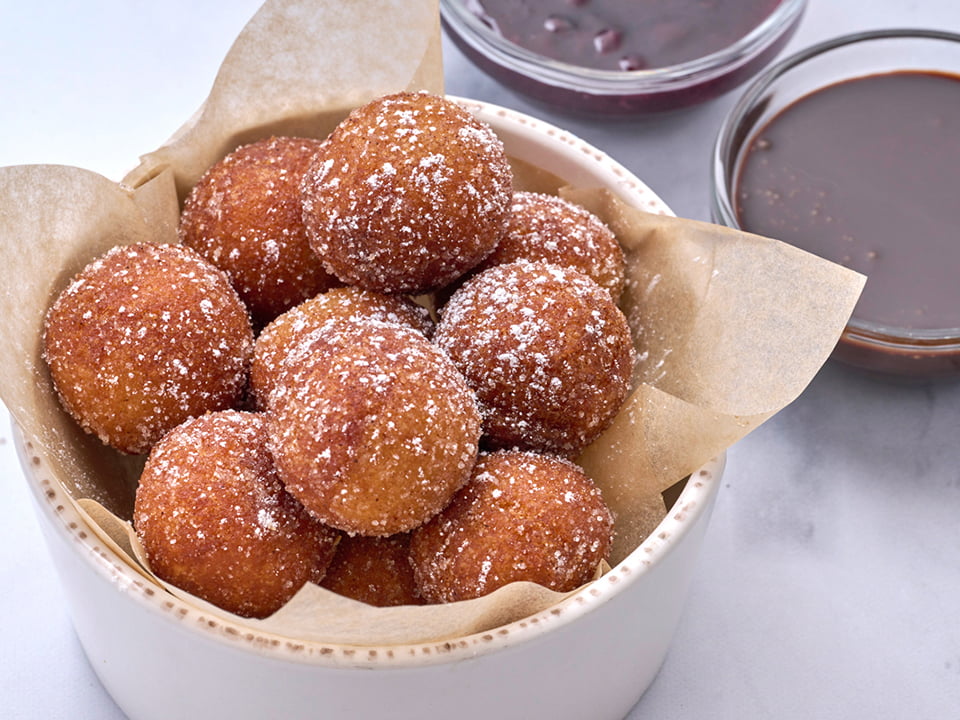 Cinnamon sugar-dusted cake donut holes with chocolate sauce and warm mixed berry compote for dipping.