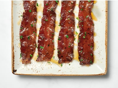 Four slices of our signature hardwood smoked bacon baked with brown sugar, black pepper, cayenne and a maple syrup drizzle