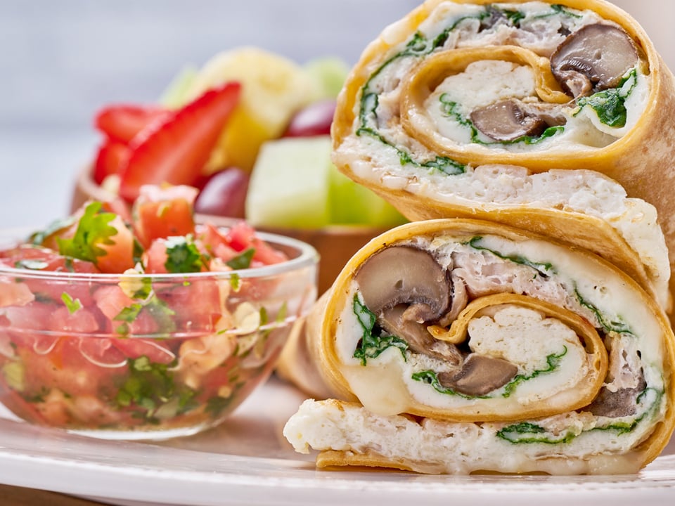 Cage-free egg whites, turkey, spinach, house-roasted Crimini mushrooms and Mozzarella in a sun-dried tomato-basil tortilla. Served with fresh fruit and a side of housemade pico de gallo.