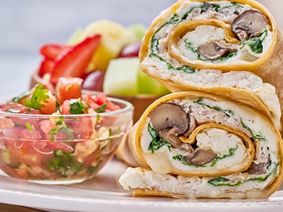 Cage-free egg whites, turkey, spinach, house-roasted Crimini mushrooms and Mozzarella in a sun-dried tomato-basil tortilla. Served with fresh fruit and a side of housemade pico de gallo.