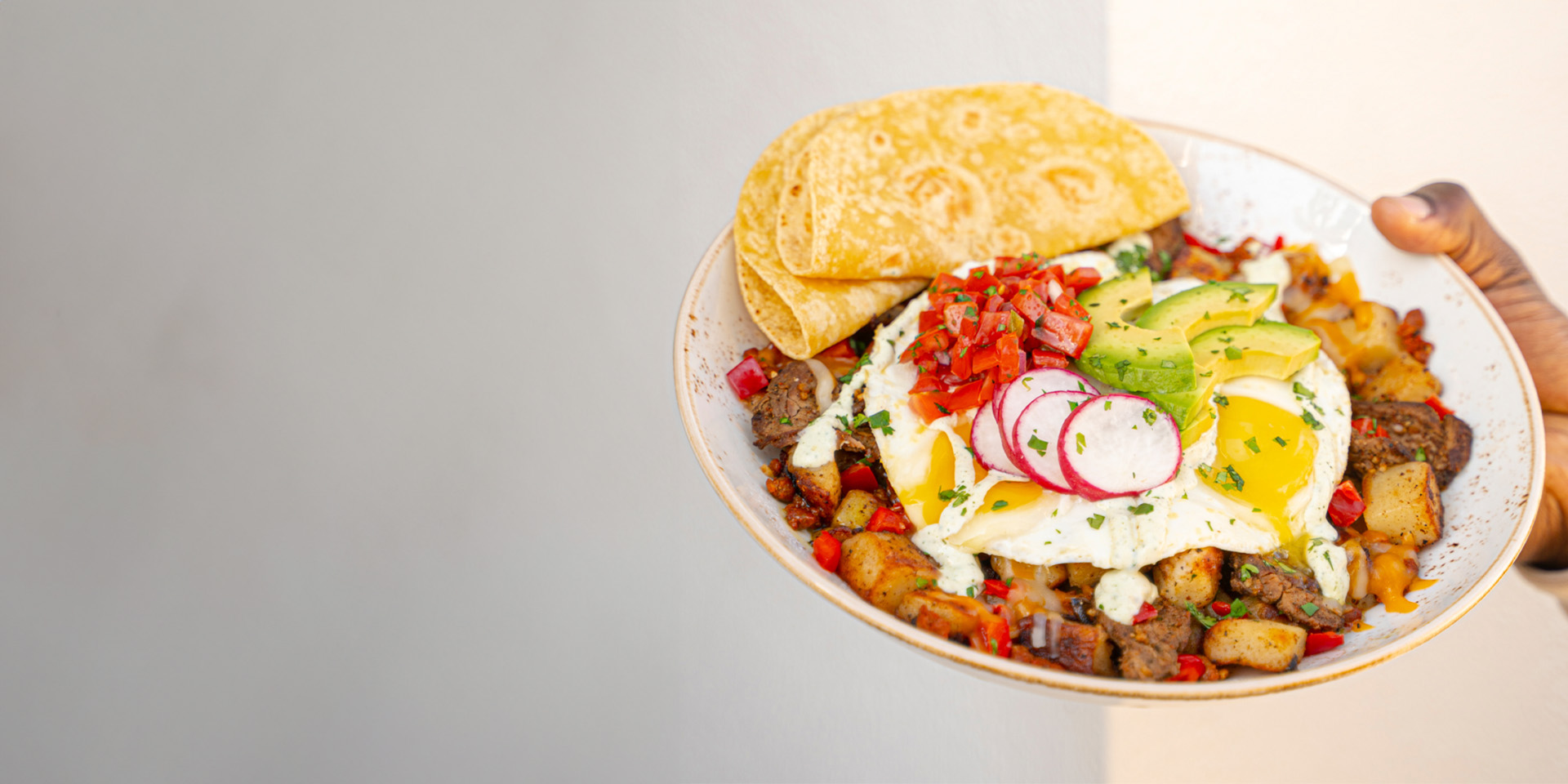 Carne Asada Hash with fresh carne asada, chorizo, bell peppers, potato hash, and pico de gallo, served with eggs and tortillas.